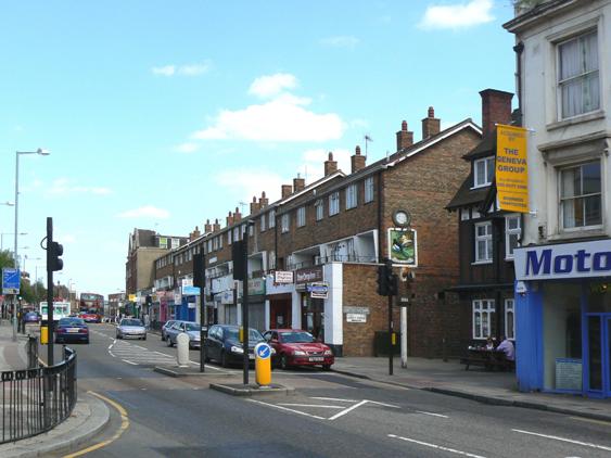 Parade of 1950s 3-storey brick-built shops and some older properties
