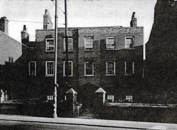 view showing 3 storey brick built Georgian property with 5 sash windows on the first and second floors, set back from the road