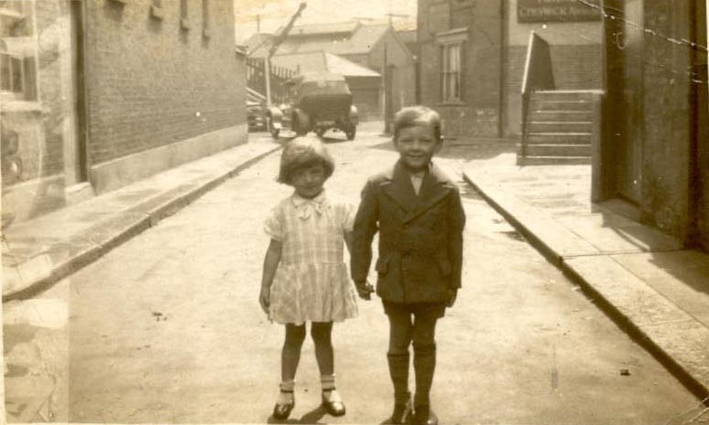 Young girl and boy standing hand in hand