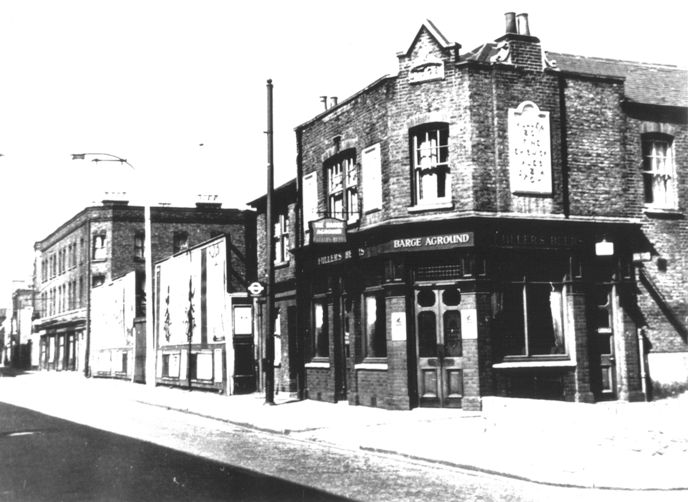 Brick built pub on corner, date plaque 1902; next to the pub,further down the High Street are advertising hoardings; there is a bus stop outside the pub