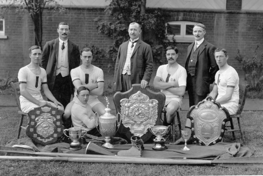 Four rowers, club officials and trophies