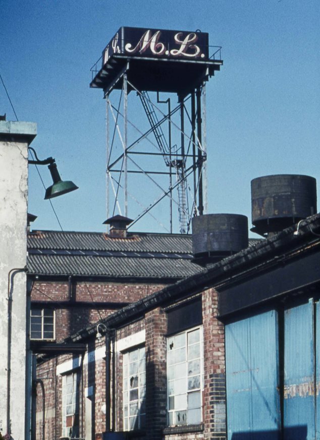 Factory view with signage 'M L' on a roof tower