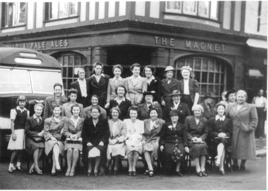 Group of 27 ladies standing by a coach