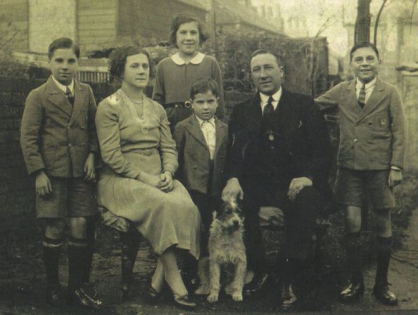Photo taken in garden, parents and their four children and a dog