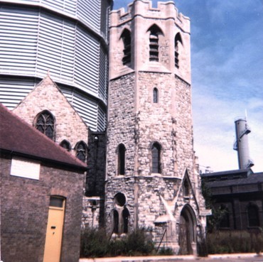 Stone church dominated by gasometer