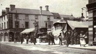 View of Market Place at fair time ca 1905, taken from High Street, with Three Pigeons Inn in background